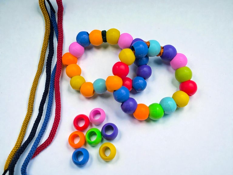 Two colorful beaded bracelets and loose pony beads with matching braided cord strings for jewelry making.