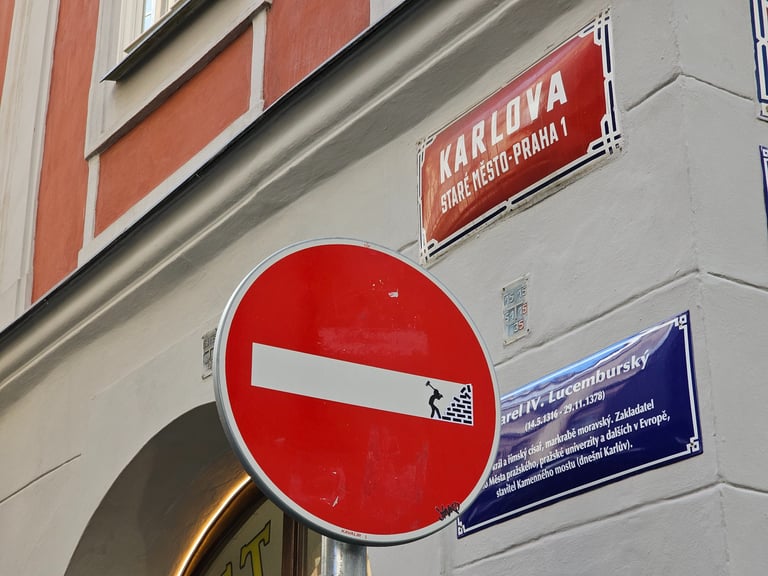 Détournement de panneaux de signalisation représentant un homme détruisant un mur sur sens interdit 