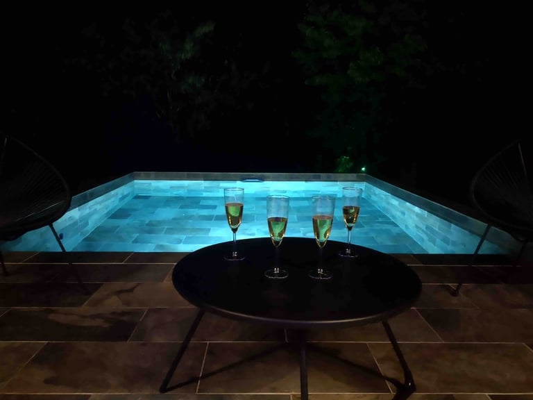 piscine de nuit avec coupes de champagne dans la love room morbihan