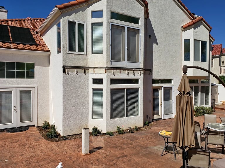 White 2 story home with spanish tile after balcony was removed.