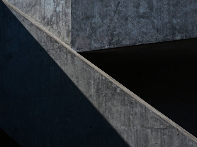 Abstract architectural lines with sharp geometric shadows on structural concrete, high-contrast minimalist composition, 35mm