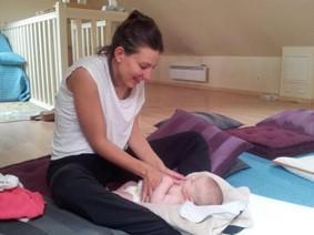 femme souriante massant son bébé