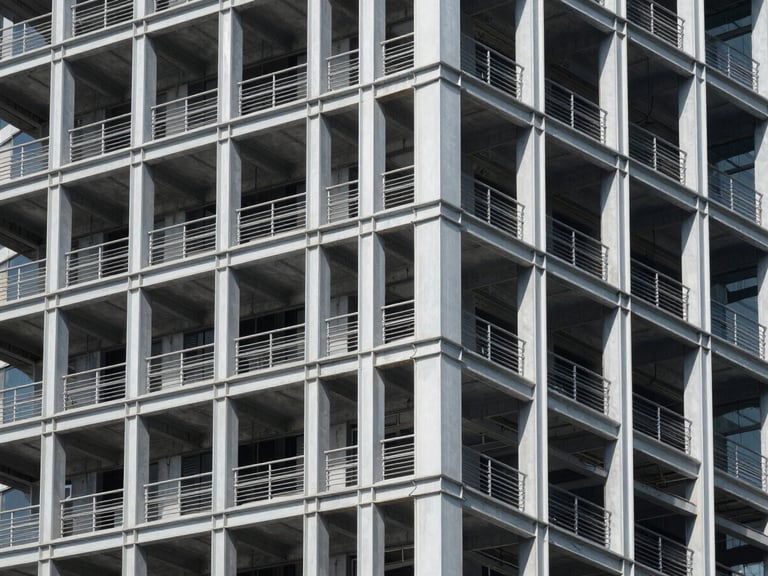 Exposed steel framework of a modern high-rise under bright daylight, clean geometric shadows, architectural photography