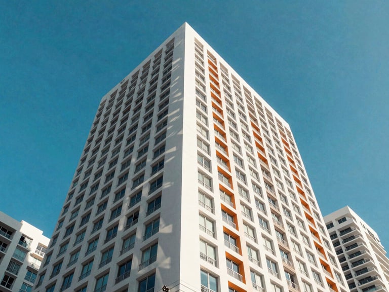 Wide-angle architectural shot of a sun-drenched Miami skyscraper facade, sharp geometric shadows, bright tropical daylight, vivid blue sky