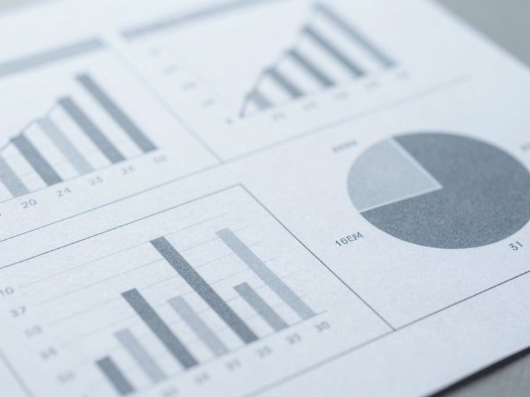 Macro detail shot of a printed statistical report with clear data charts, clean workspace, cool diffused daylight, desaturated slate tones.