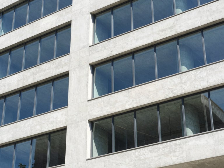 Abstract architectural geometry of concrete and glass reflecting modern structure, clean lines, bright natural daylight