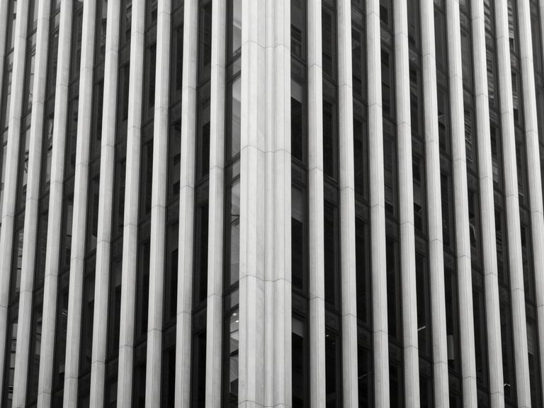 Minimalist architectural detail of a modern skyscraper facade in New York, clean lines, high contrast black and white lighting, negative space.
