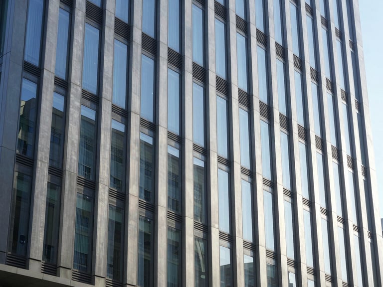 Wide environmental shot of a modern corporate office building facade with clean lines and reflective glass, bright natural daylight, 35mm lens