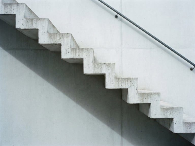 Minimalist architectural detail of concrete stairs and sharp shadows, soft overcast daylight, cool desaturated tones, 35mm