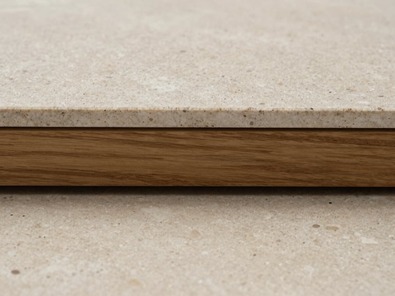 Extreme close-up of a raw travertine floor slab meeting a wire-brushed oak threshold, straight-on elevation, soft natural daylight.