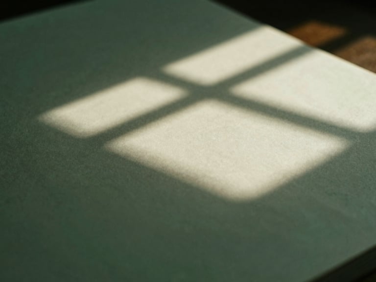Subdued editorial photograph, soft natural window light casting architectural shadows on a heavy paper document, deep forest green tones, macro close-up, 35mm