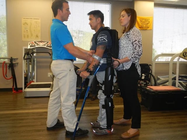 Joven en una clínica de rehabilitación con exoesqueleto rewalk