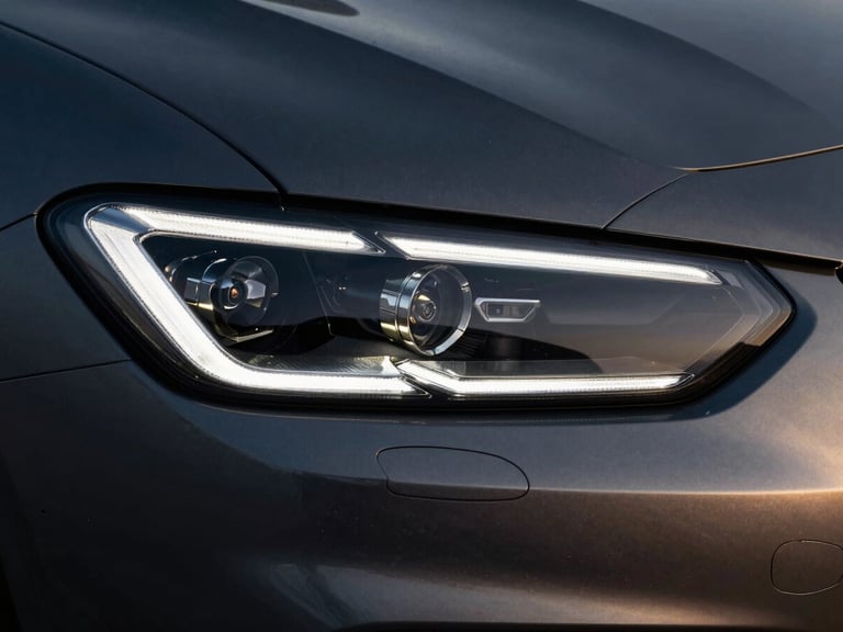 Extreme close-up of a modern sports car headlight, sharp geometric LED elements, cold metallic silver reflections, dark studio lighting, 35mm lens.