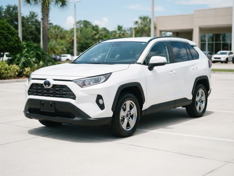 Crisp eye-level portrait of a clean, practical white SUV parked on a neat concrete lot under bright natural Florida daylight.