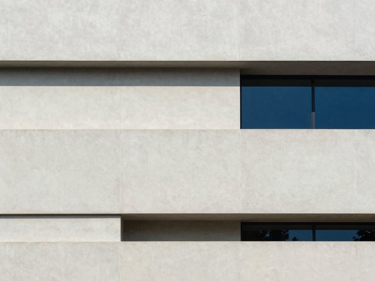 Minimalist architectural photography of a modern concrete building facade in Hyderabad, soft natural daylight, clean geometric lines, 35mm