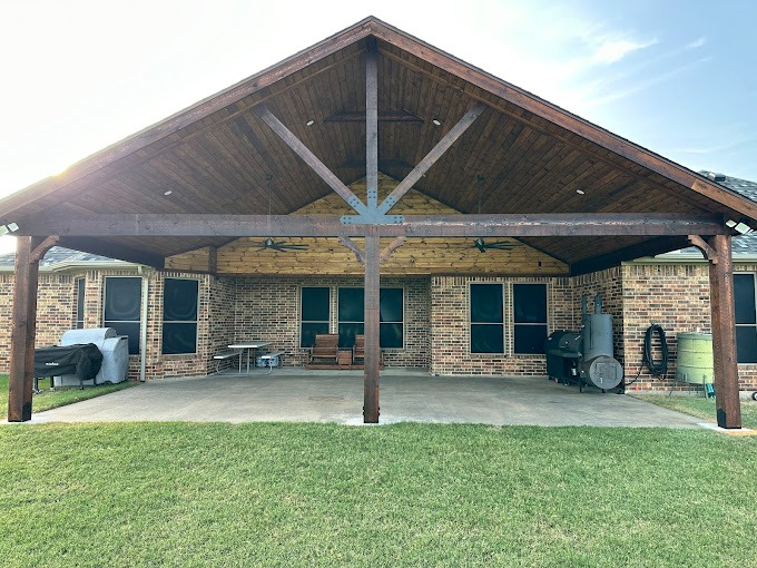 Larged covered patio with a vaulted wooden ceiling.