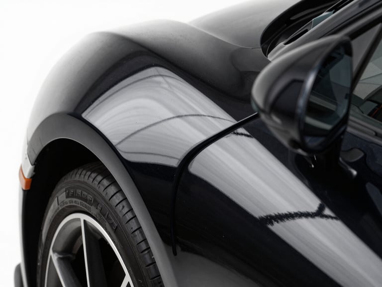 Extreme close-up of a high-end sports car fender, clinical white studio light reflecting sharp lines on deep black paint, macro detail, 50mm