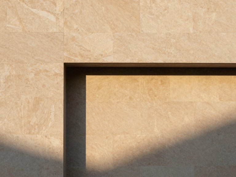 Minimalist architectural detail of a warm stone facade under soft morning sunlight, sharp structural shadows, warm earth tones, 35mm editorial photography