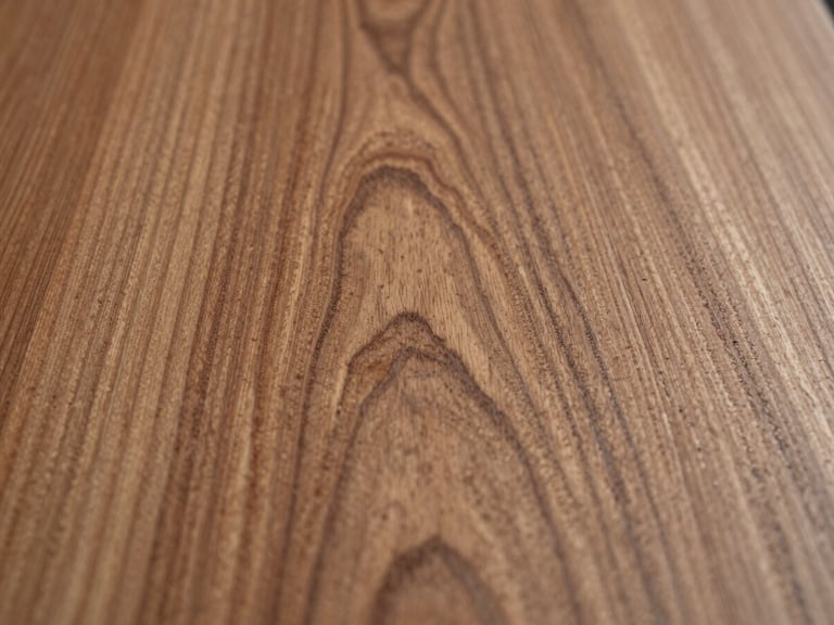 Macro overhead shot of hand-planed cherry wood, showcasing the highly detailed, organic grain patterns and rich natural texture under soft, directional side-light.