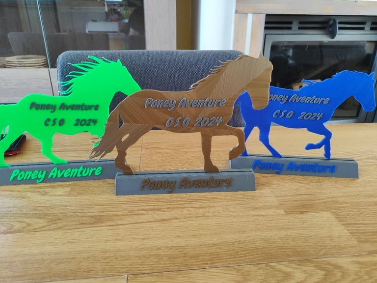 trophees en forme de cheval vert, marron et bleu