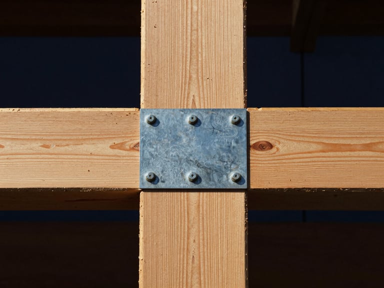 Straight-on close-up of a heavy timber beam joined to a steel plate with exposed bolts, high-contrast daylight, sharp focus