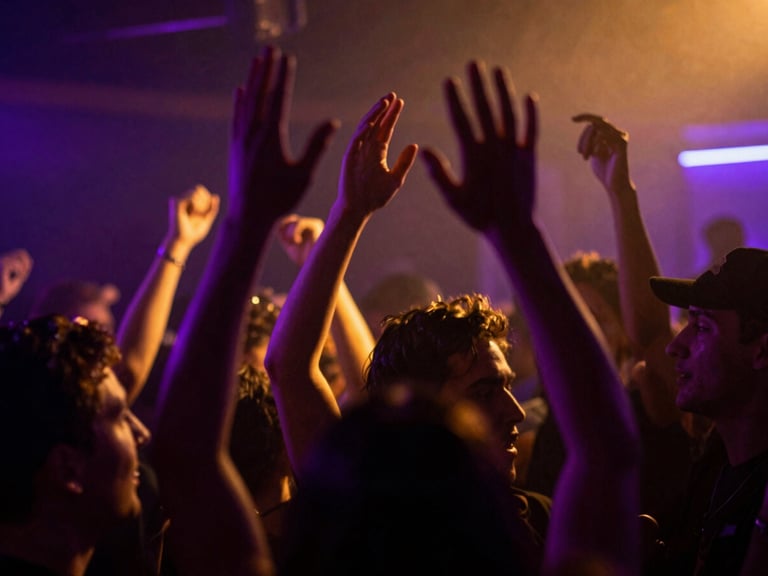 Dynamic low-angle shot of a crowd in motion blur under neon-violet and gold light leaks, hands raised, high-contrast club atmosphere, 35mm lens.