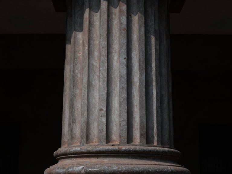 Architectural detail of an Indian legislative pillar in low-key side-lighting, deep shadows, sharp focus, 50mm.