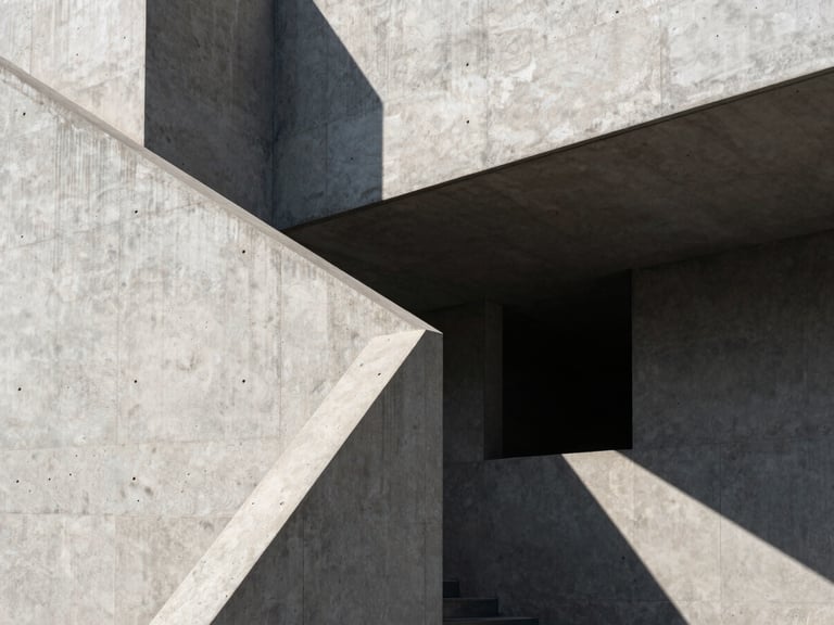 Sharp architectural concrete geometry under direct, high-contrast sunlight with deep shadows, clean lines, minimalist composition