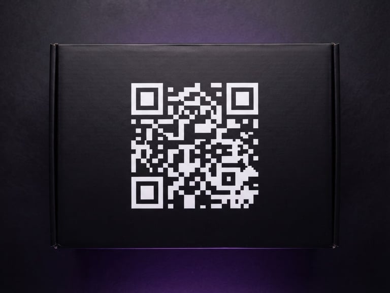 Overhead flat-lay of premium matte-black product packaging with a crisp, high-contrast custom QR code printed on the side, studio lighting, purple ambient glow