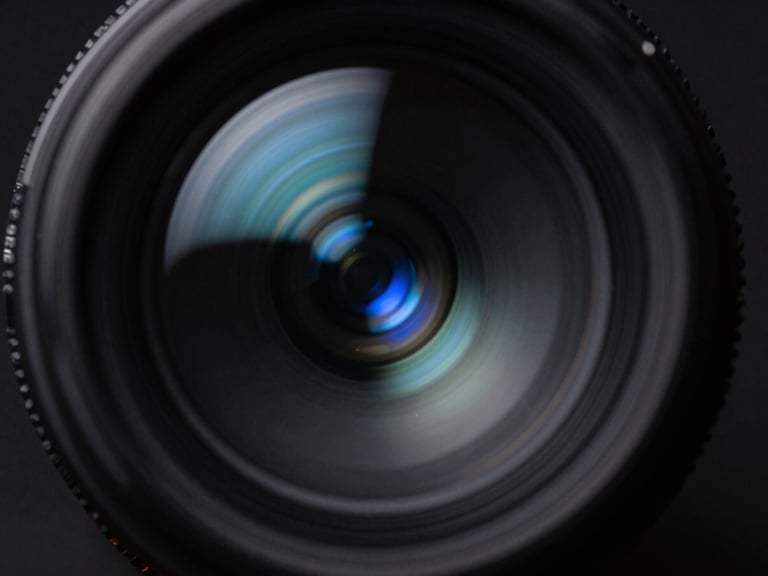 Macro shot of optical glass refracting blue light beams, dark obsidian background, sharp directional light, cool-toned shadows, 35mm lens.