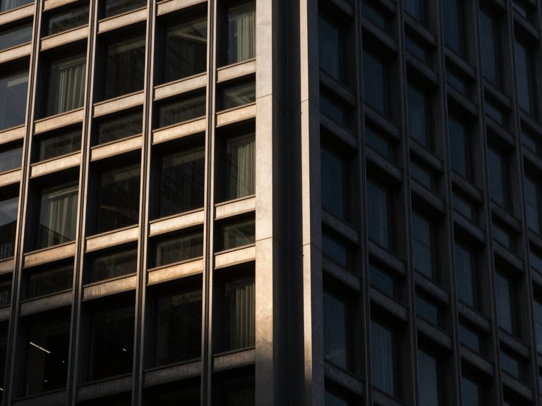 Extreme close-up of a modern steel-and-glass skyscraper structural joint, dramatic sharp shadows, high-contrast architectural lighting