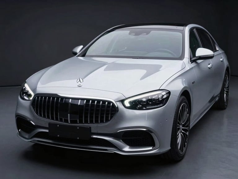 Wide panoramic dark-studio shot of a luxury sedan with full-front PPF installation complete, studio strobes illuminating the hood and front bumper surface at a 45-degree angle, the transparent film creating a faint sculptural sheen across the nose of the vehicle, deep charcoal background