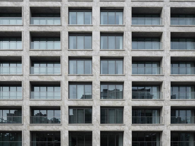 Symmetric modern building facade made of light grey natural stone and glass, clean lines, balanced architectural composition