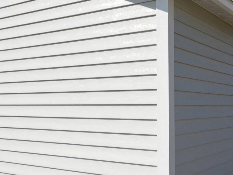 Wide shot of a home with new James Hardie fiber cement siding, architectural angles, bright natural daylight, clean high-contrast tones, sharp focus, 35mm lens