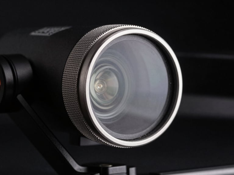 Macro shot of a Freewell drone filter mounted on a gimbal, showing the knurled metallic ring and pristine glass, sharp rim lighting against a dark background, 85mm.
