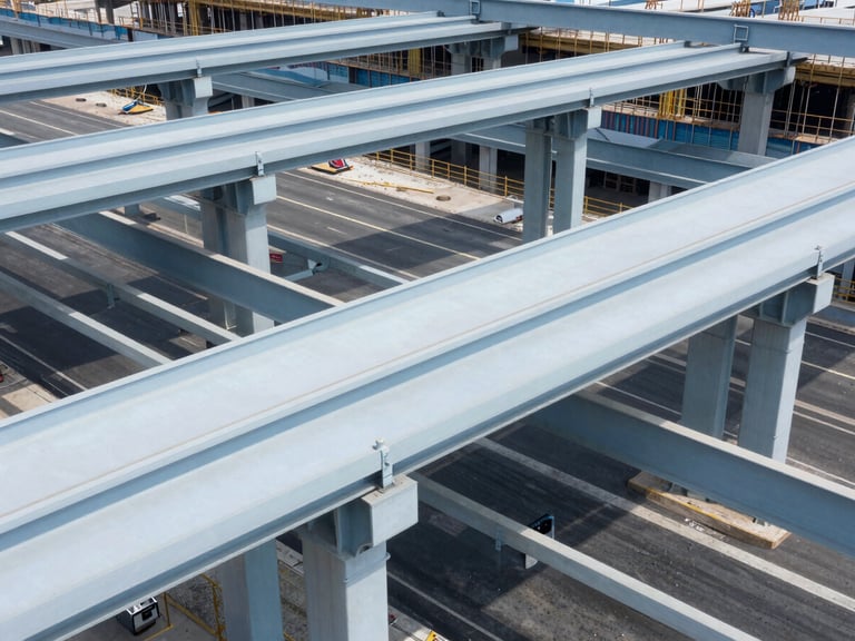 High-angle architectural photograph of a major highway interchange under construction, steel girders, clean blue tones, bright daylight