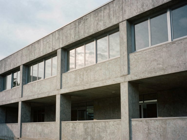 Quiet architectural detail of a modern concrete research facility facade, sharp overcast daylight, deep shadows, minimalist design, editorial film style.