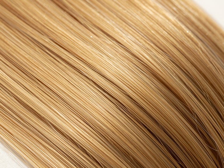 Macro close-up of premium double-drawn hair extensions catching natural golden hour sunlight, highlighting clean texture and sheen