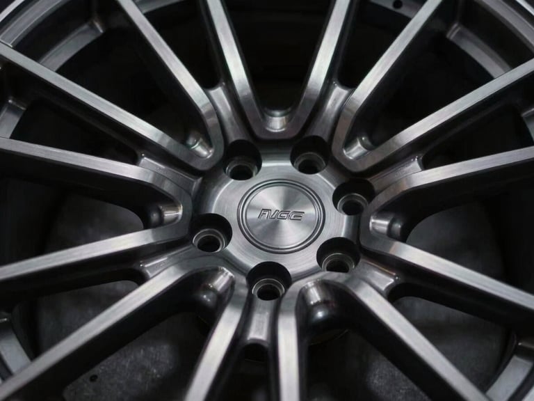 Extreme close-up of a custom multi-piece forged wheel, precision billet-aluminum machining details, dramatic low-key studio lighting, shallow depth of field, 35mm anamorphic