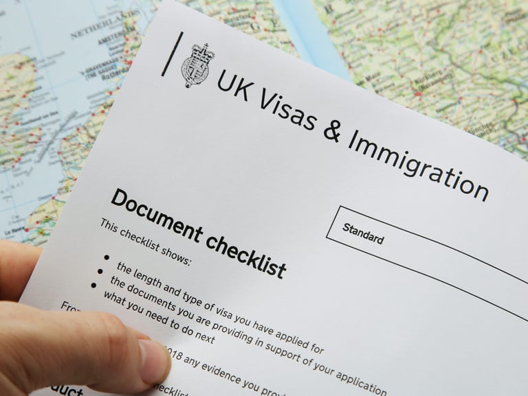 Person holding UKVI Document checklist in left hand