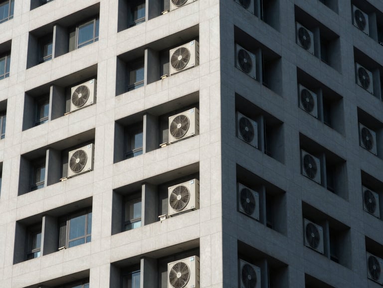 Clean architectural lines of a commercial high-rise exterior, showing industrial HVAC installations under sharp architectural shadows.