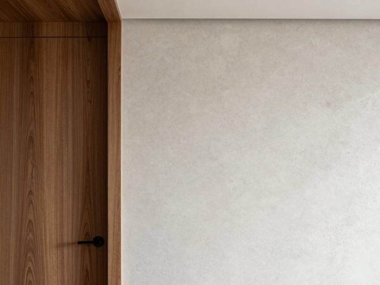 Meticulous interior fit-out showing a flawless transition between walnut wood paneling and microcement wall, clean minimalist architecture.
