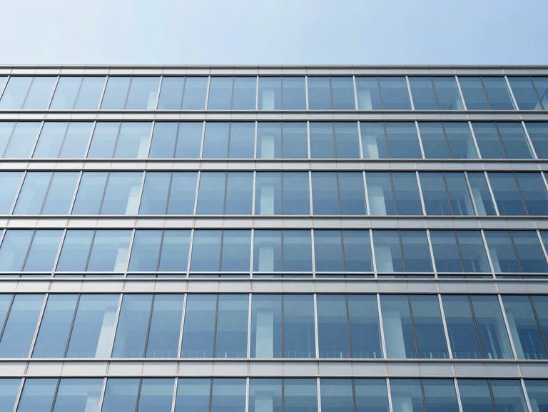 Wide-angle architectural shot of a structural glass facade, crisp blue sky reflection, clean minimalist composition, high contrast