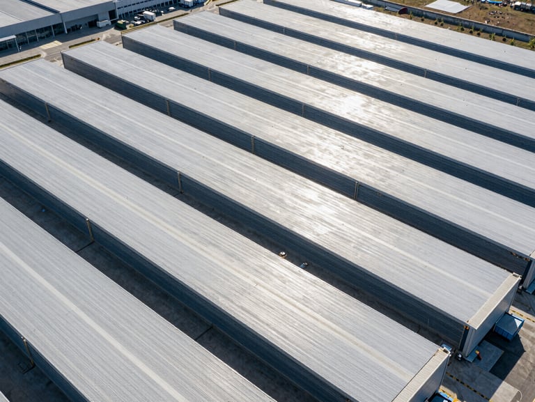 Aerial pattern of a modern logistics and distribution center, clean organized lines, high-contrast lighting.