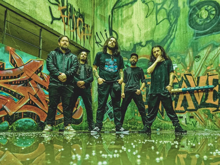Heavy metal band posing in an abandoned building with green and orange graffiti walls.
