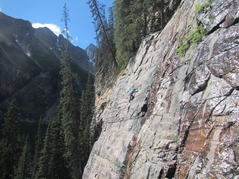 a person climbing a mountain side of a cliff