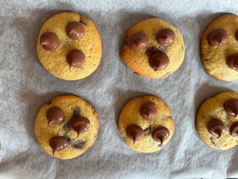 a bunch of chocolate chip cookies on a baking sheet