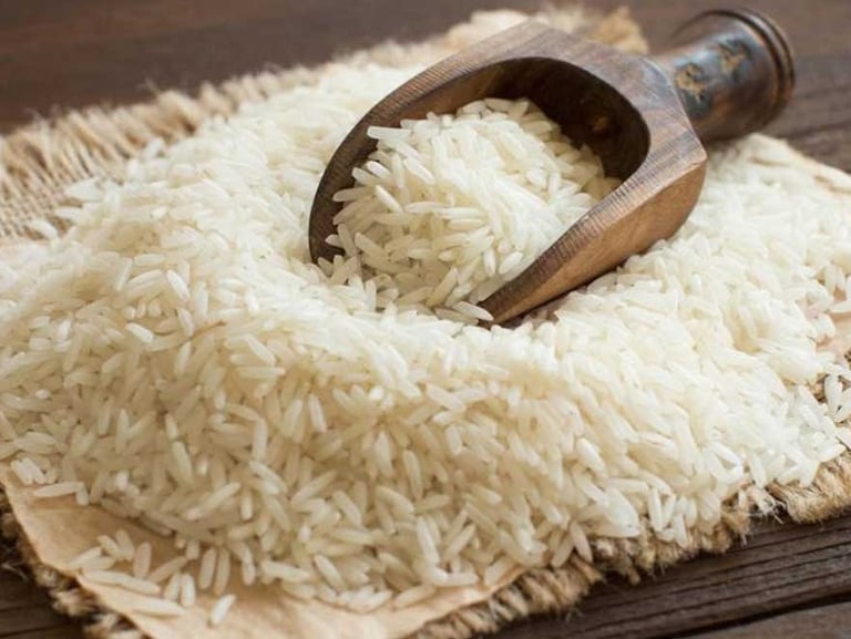 loose basmati rice grains with a rustic wooden  scoop