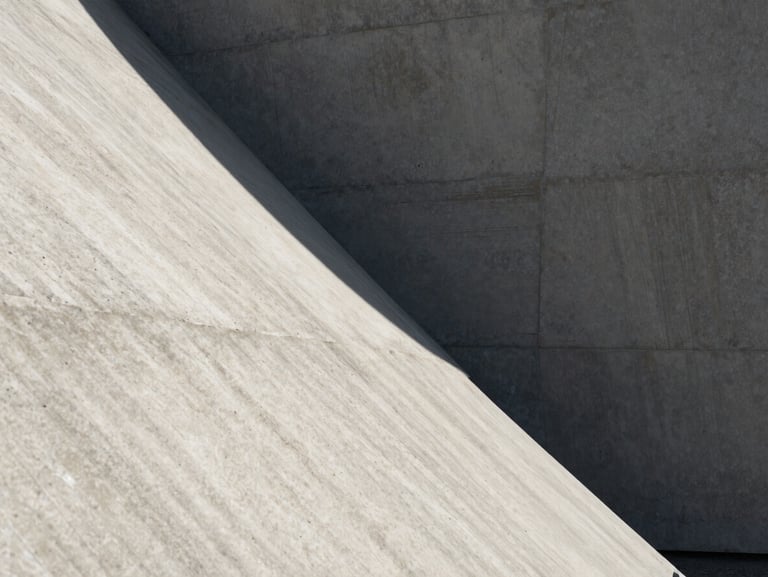 Tight, abstract architectural crop of intersecting concrete planes, sharp diagonal shadows cast by harsh midday sun, emphasizing raw material texture.