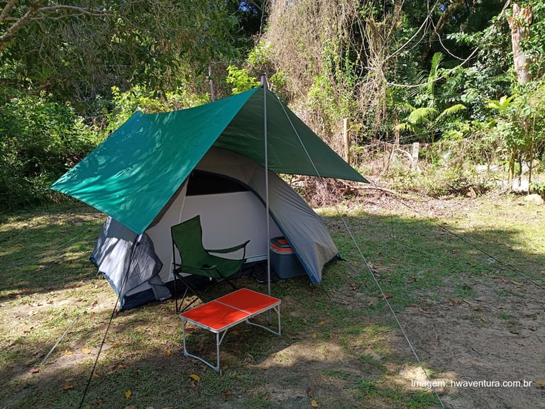 acampamento montado com barraca, toldo, mesa portátil e cadeira